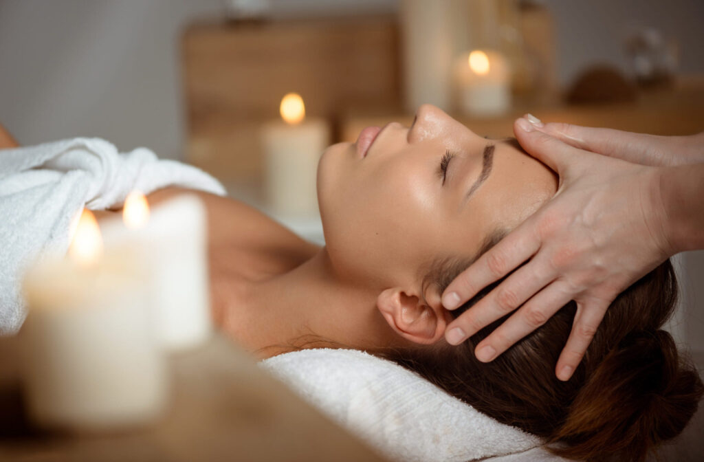 Young beautiful girl having face massage relaxing in spa salon